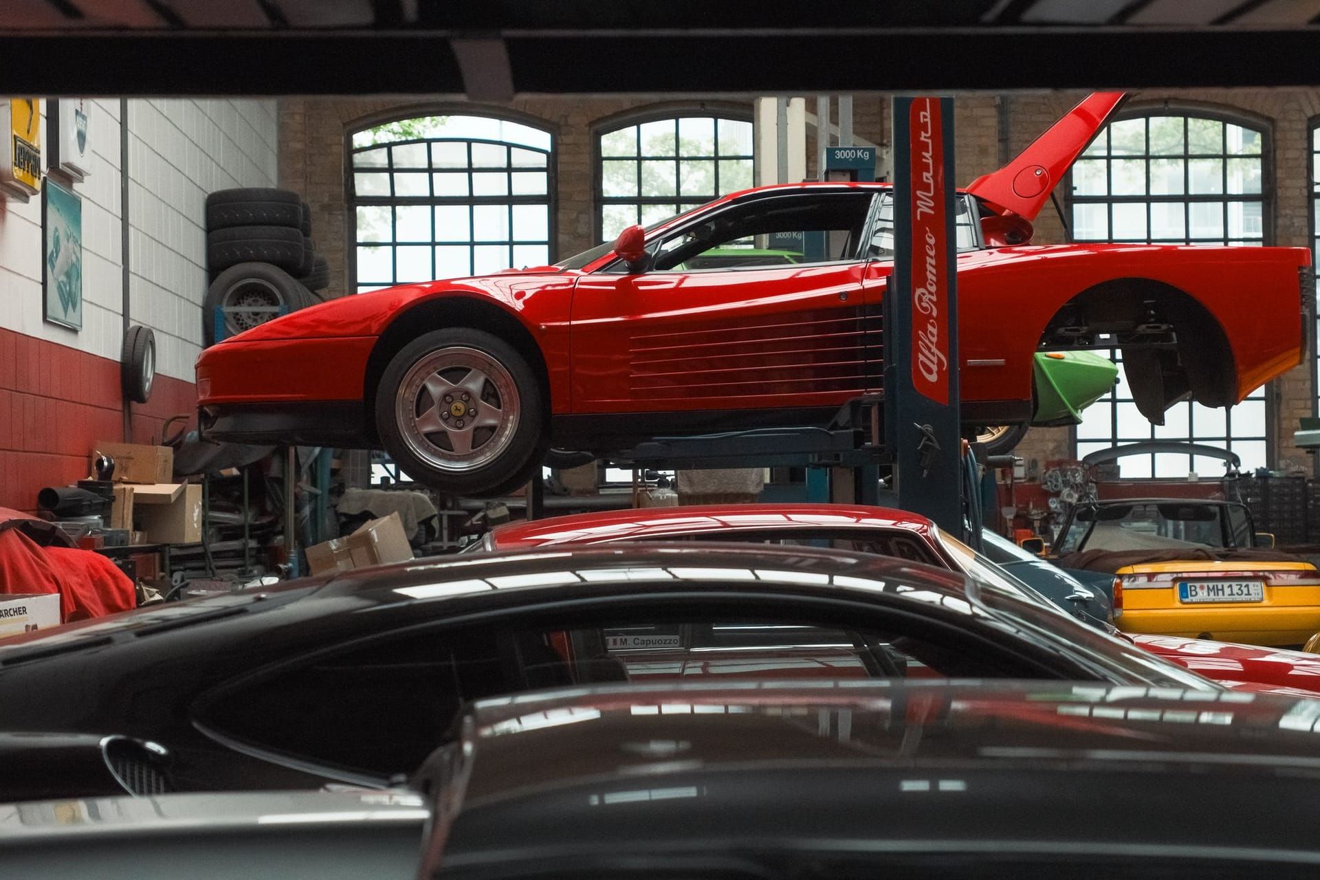 Red sports car raised on a lift in an auto repair shop