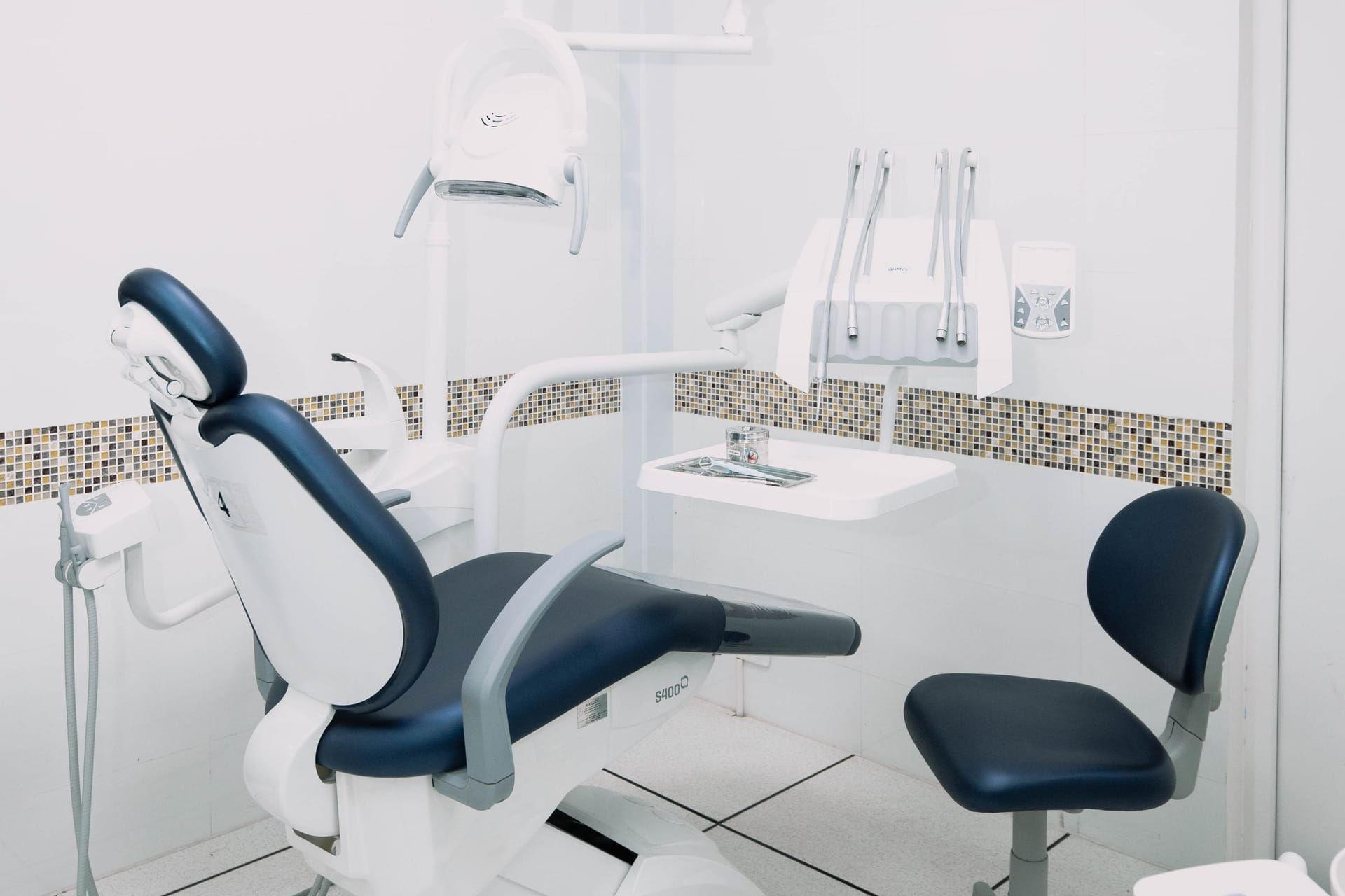 Bright dental treatment room with a patient chair and overhead light