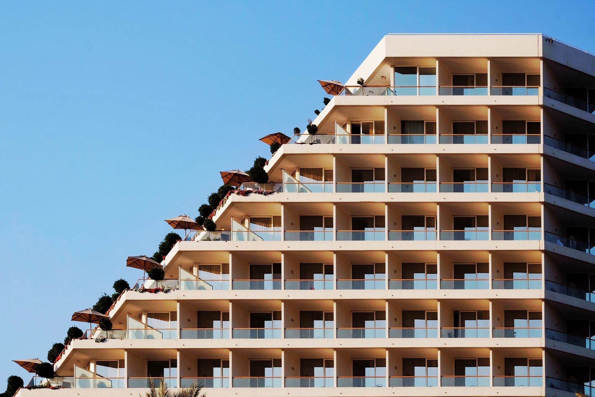 Hotel building with stepped balconies against a blue sky