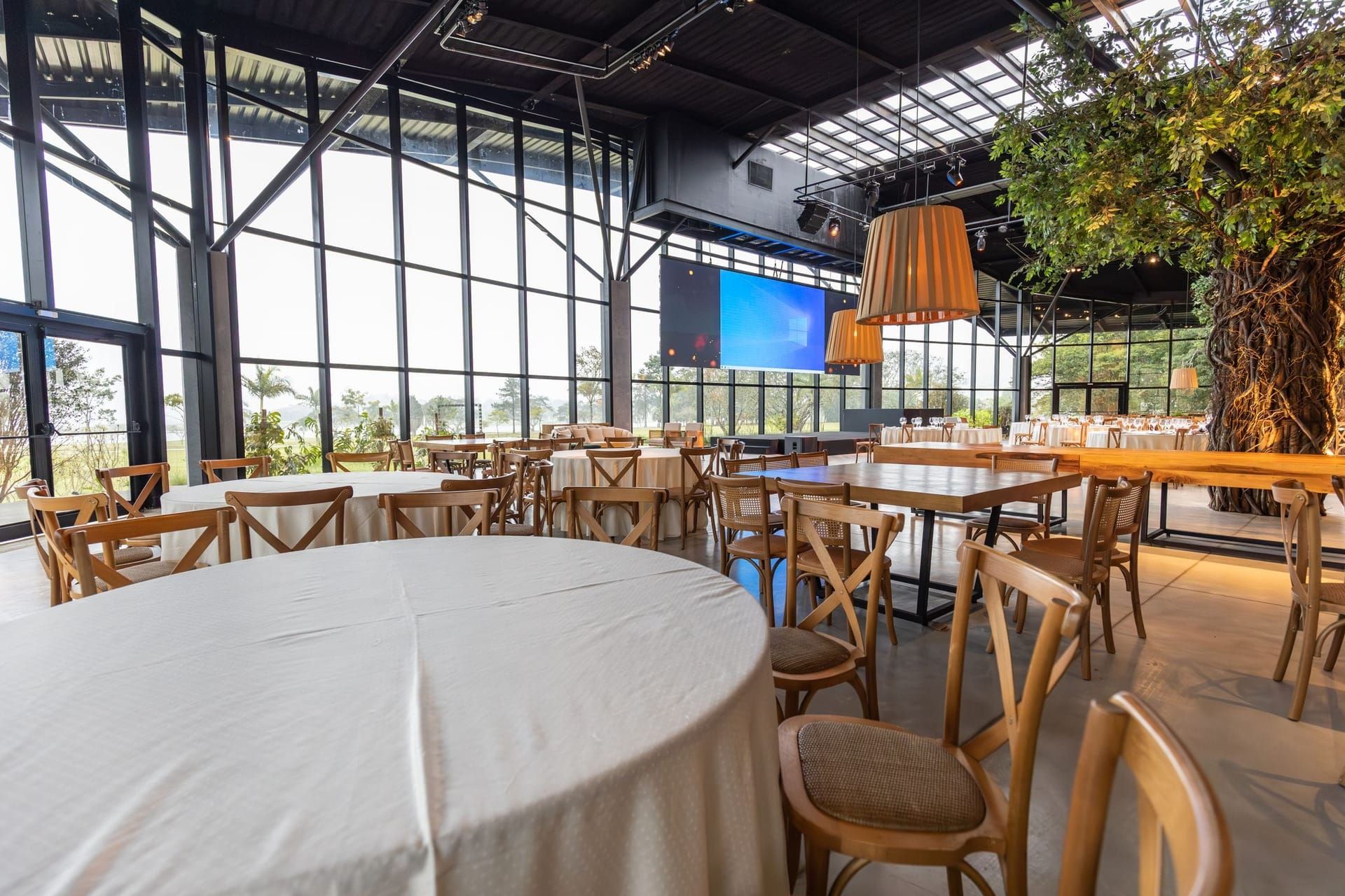 Bright restaurant dining room with wooden tables and tall windows